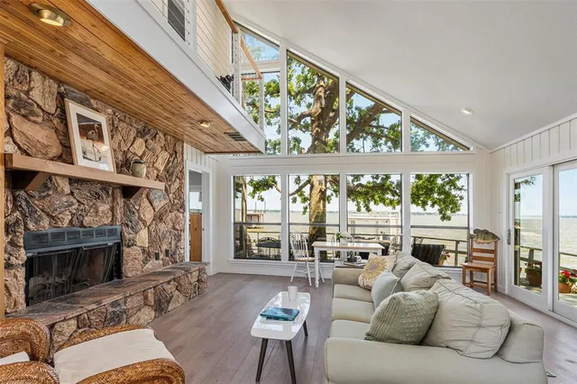a living room with furniture a fireplace and a large window