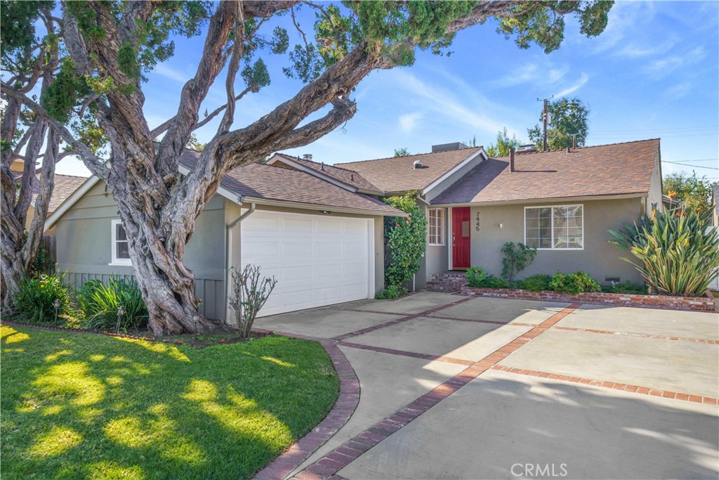 a front view of a house with a garden and plants