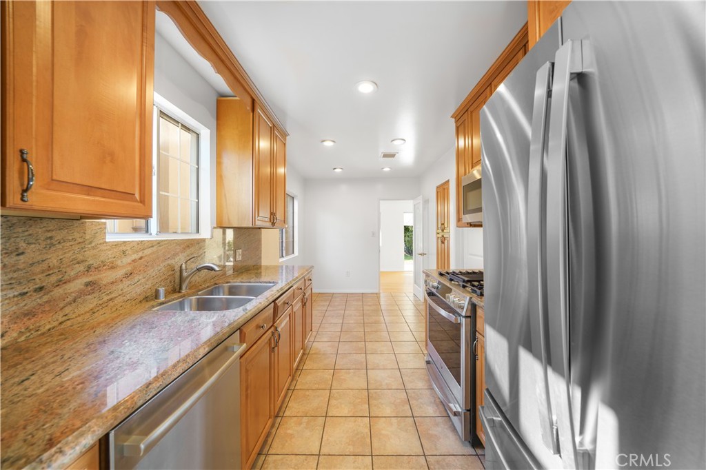 7445 Mammoth Avenue Van Nuys, CA 91405 - Photo 13 of 33 a kitchen with granite countertop a sink and a refrigerator