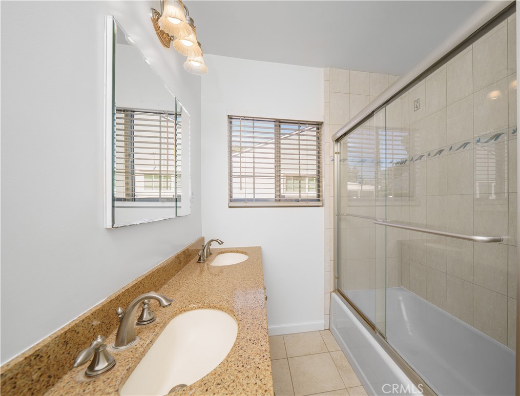 7445 Mammoth Avenue Van Nuys, CA 91405 - Photo 21 of 33 a bathroom with a granite countertop sink and a mirror