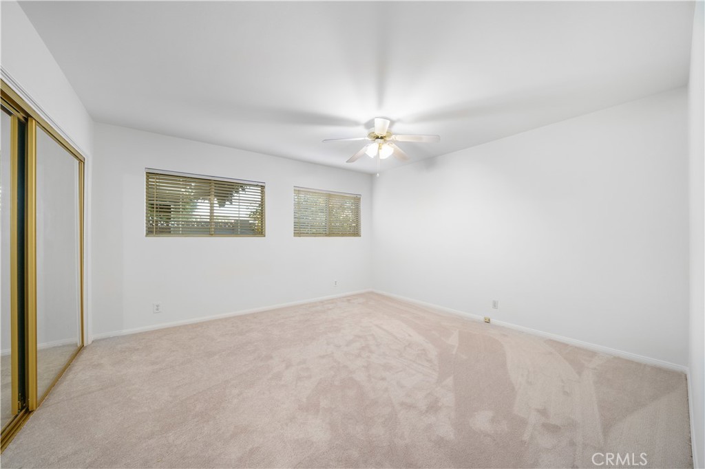 7445 Mammoth Avenue Van Nuys, CA 91405 - Photo 26 of 33 an empty room with a chandelier fan and windows