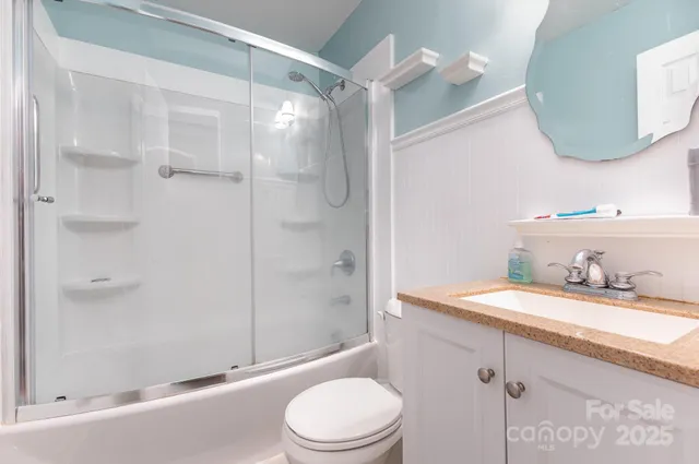 a bathroom with a granite countertop sink toilet a mirror and shower