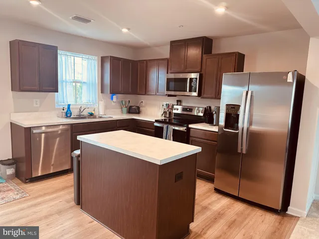 a kitchen with stainless steel appliances a refrigerator sink stove microwave and cabinets