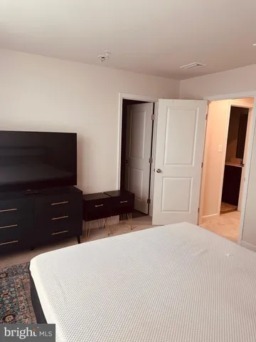 a bedroom with a bed and a flat screen tv