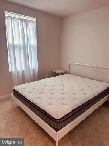 a bed sitting in a bedroom next to a window