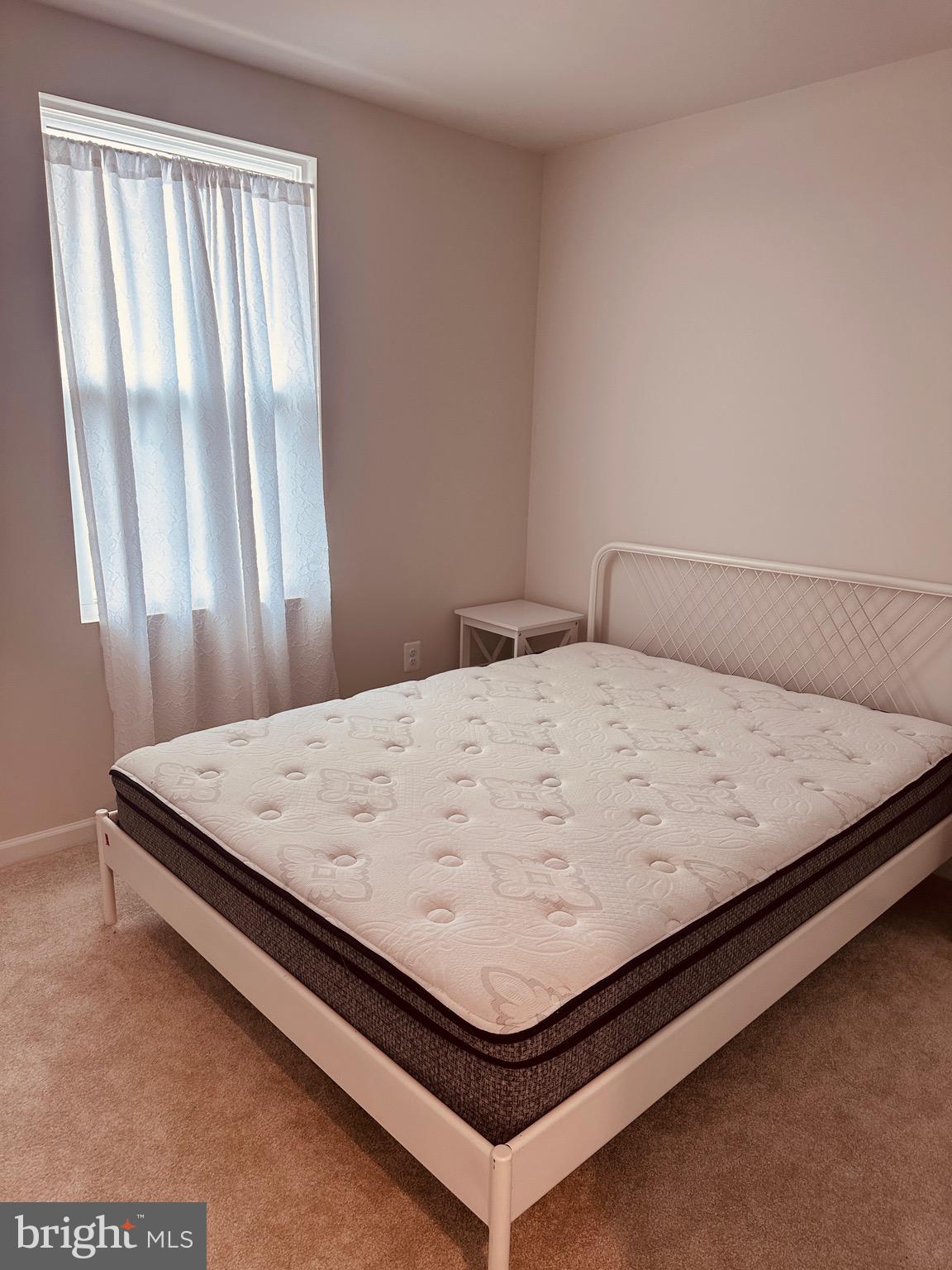 309 Yellow Bill Lane, Unit JUNIPER Cambridge, MD 21613 - Photo 20 of 25 a bed sitting in a bedroom next to a window