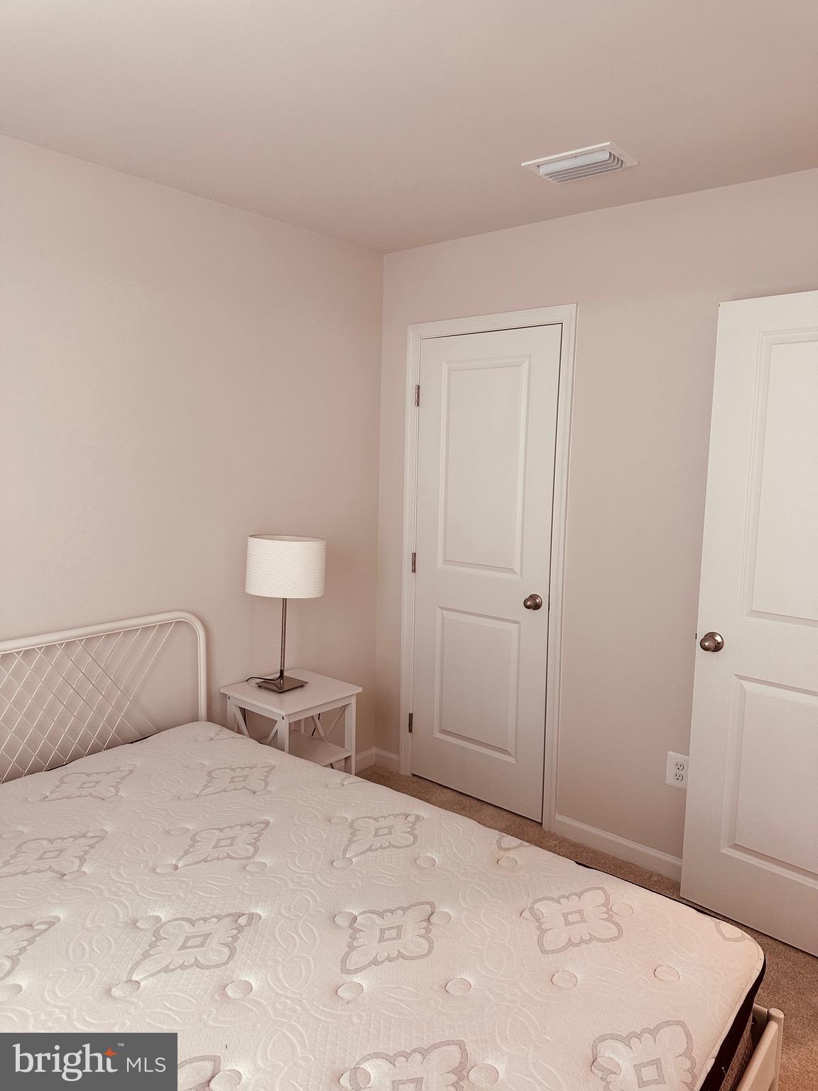 309 Yellow Bill Lane, Unit JUNIPER Cambridge, MD 21613 - Photo 21 of 25 a bedroom with a bed and a lamp