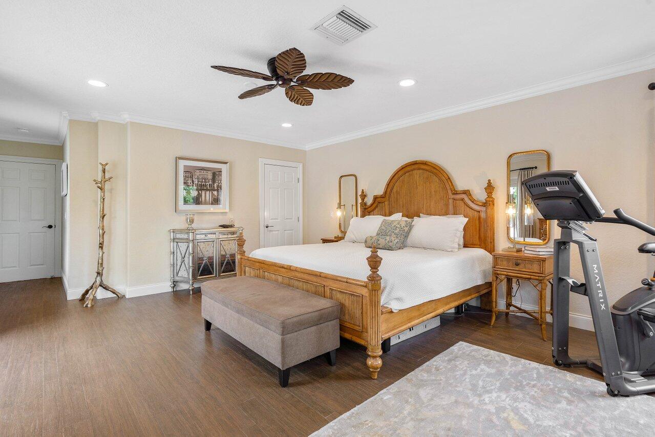 601 Phillips Drive Boca Raton, FL 33432 - Photo 20 of 56 a spacious bedroom with a bed a chandelier and a dresser