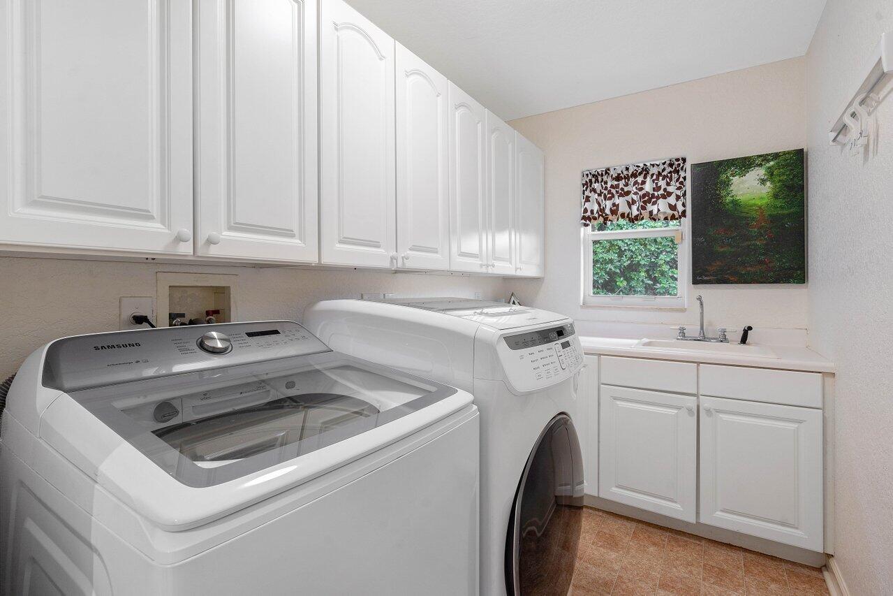 601 Phillips Drive Boca Raton, FL 33432 - Photo 32 of 56 a view of washer and dryer with kitchen countertops