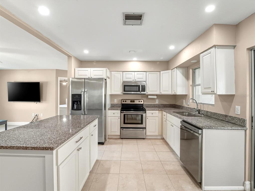 1017 Rosedale Road Venice, FL 34293 - Photo 5 of 30 a large kitchen with granite countertop a large counter top stainless steel appliances and cabinets