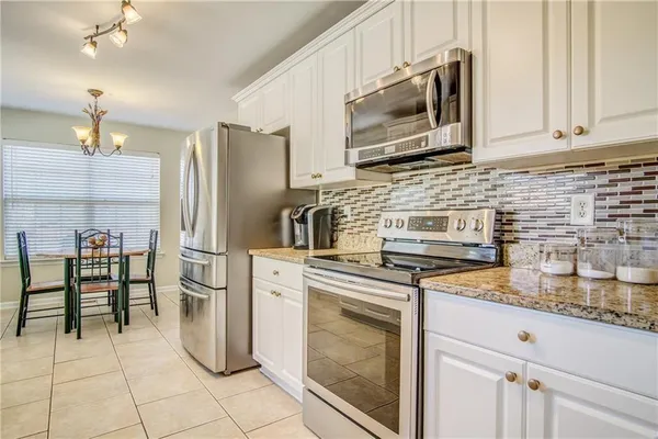a kitchen with appliances cabinets and furniture