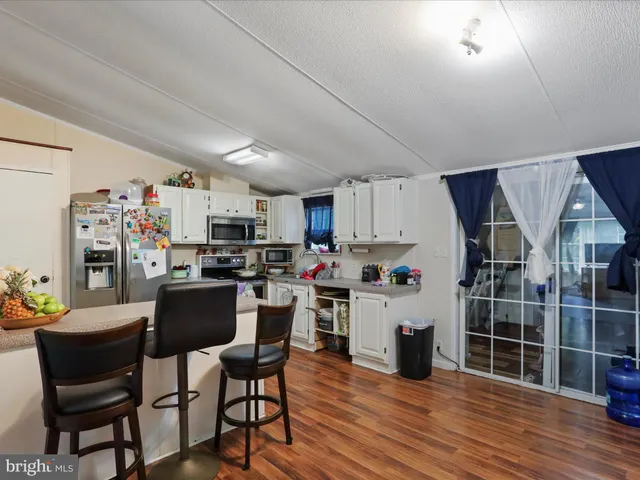 a living room with furniture a wooden floor and next to a window