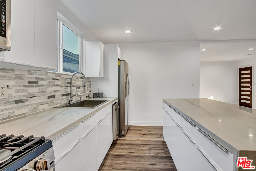 2419 South Cochran Avenue Los Angeles, CA 90016 - Photo 12 of 74 a kitchen with stainless steel appliances granite countertop a sink stove and cabinets