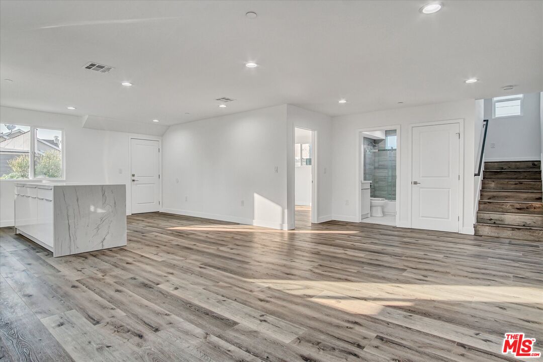 2419 South Cochran Avenue Los Angeles, CA 90016 - Photo 59 of 74 a view of an empty room with wooden floor and kitchen
