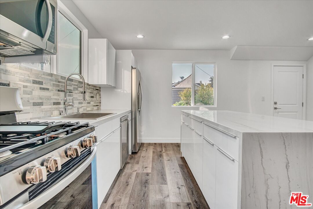 2419 South Cochran Avenue Los Angeles, CA 90016 - Photo 61 of 74 a kitchen with stainless steel appliances a sink stove and refrigerator