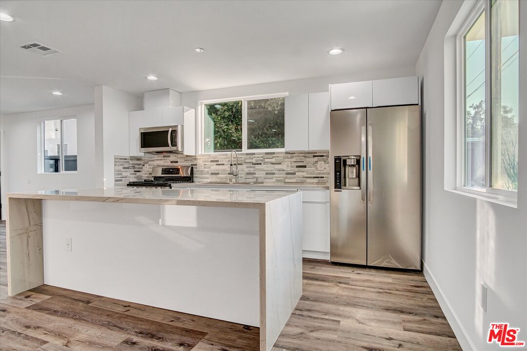 2419 South Cochran Avenue Los Angeles, CA 90016 - Photo 64 of 74 a kitchen with kitchen island granite countertop a refrigerator stove top oven and sink