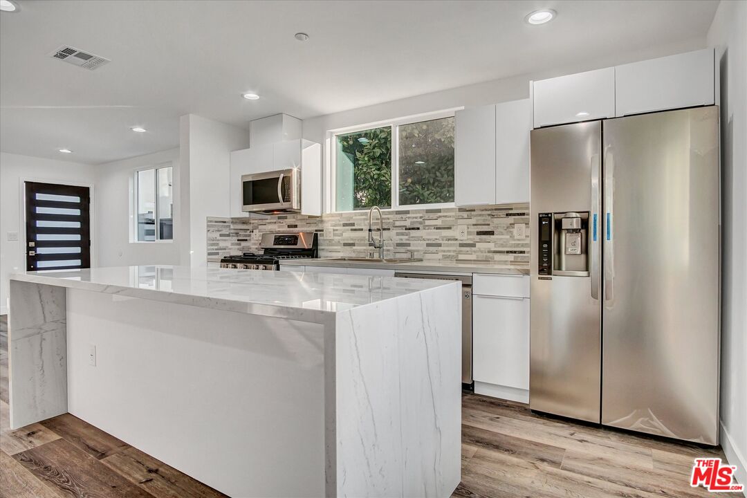 2419 South Cochran Avenue Los Angeles, CA 90016 - Photo 65 of 74 a kitchen with stainless steel appliances a refrigerator sink and microwave