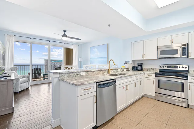 a kitchen with kitchen island white cabinets and stainless steel appliances