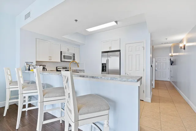 a kitchen with granite countertop white cabinets and stainless steel appliances