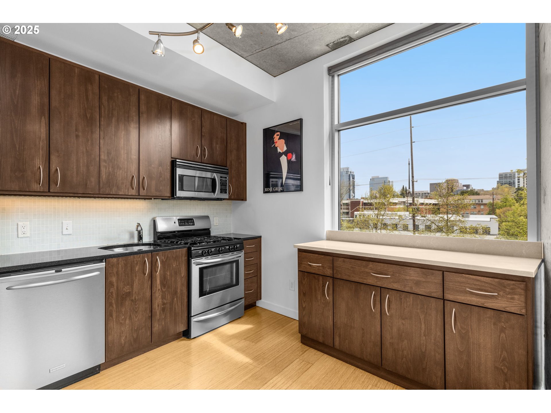 1234 Southwest 18th Avenue, Unit 305 Portland, OR 97205 - Photo 12 of 31 a kitchen with stainless steel appliances granite countertop a stove a sink dishwasher and a microwave oven with cabinets