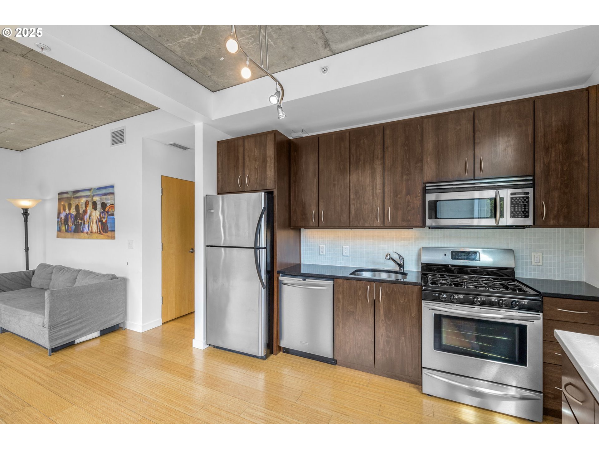 1234 Southwest 18th Avenue, Unit 305 Portland, OR 97205 - Photo 8 of 31 a kitchen with granite countertop a refrigerator and a stove top oven