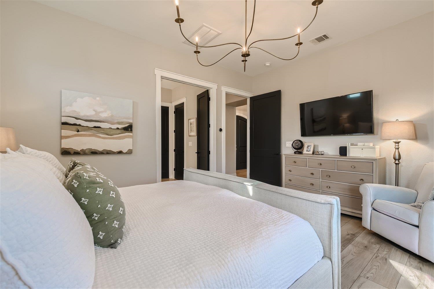 113 Vista View Trail Spicewood, TX 78669 - Photo 16 of 30 a bedroom with a bed couch and flat screen tv