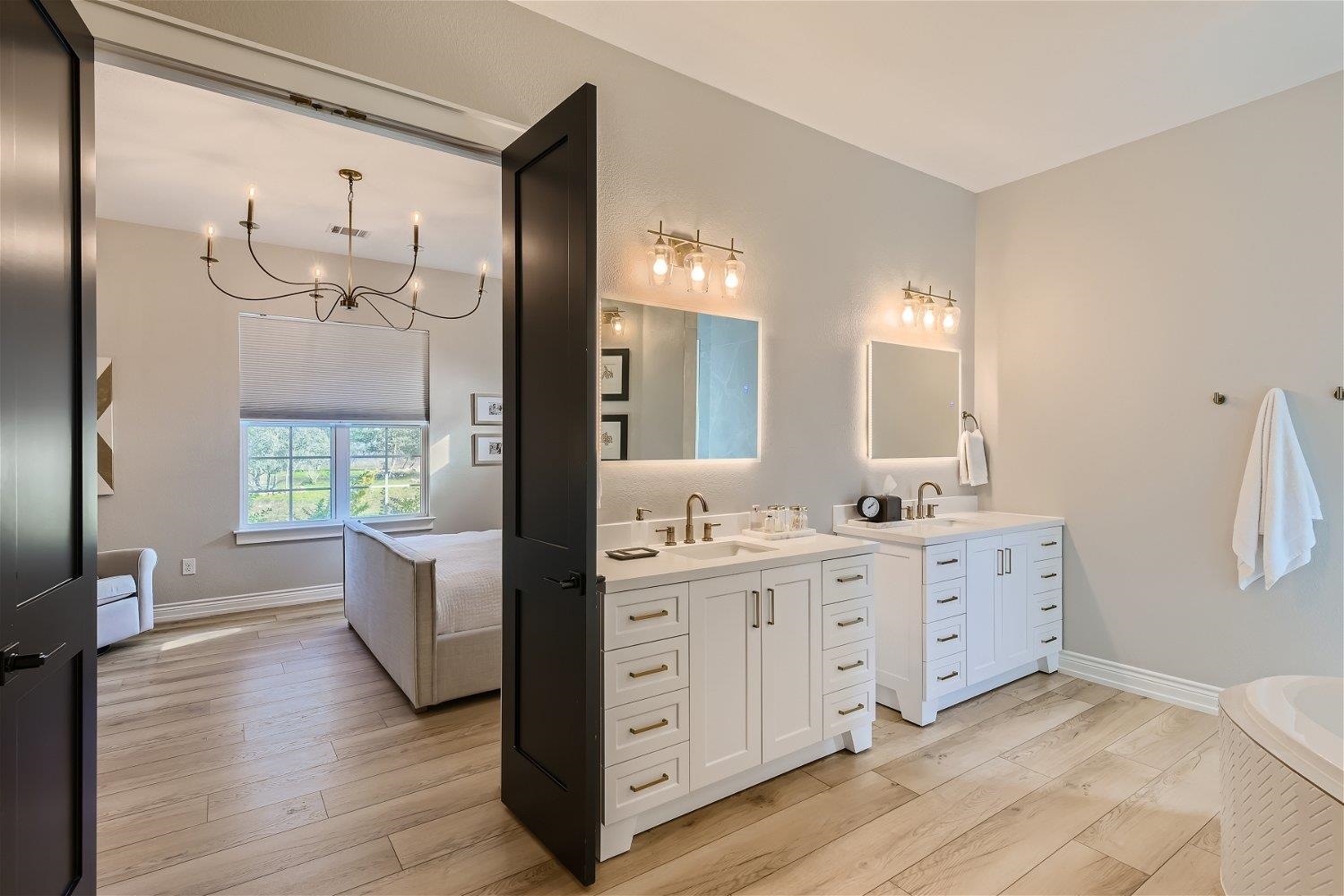 113 Vista View Trail Spicewood, TX 78669 - Photo 18 of 30 a spacious bathroom with a double vanity sink a large mirror and a bathtub