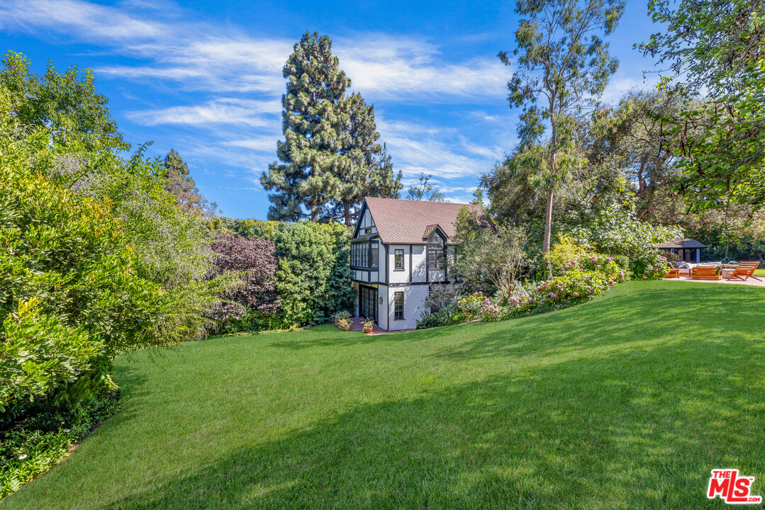 1575 Capri Drive Pacific Palisades, CA 90272 - Photo 20 of 41 a view of a big house with a big yard and large trees