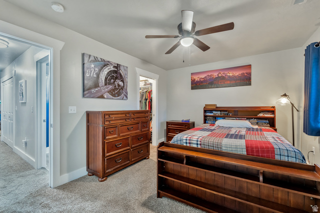 Undisclosed Address Ogden, UT 84403 - Photo 15 of 21 Bedroom with light carpet, a ceiling fan, and a walk in closet