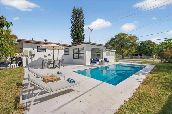a view of a house with swimming pool and sitting area