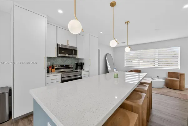 a kitchen with stainless steel appliances granite countertop a sink a stove and a wooden floors