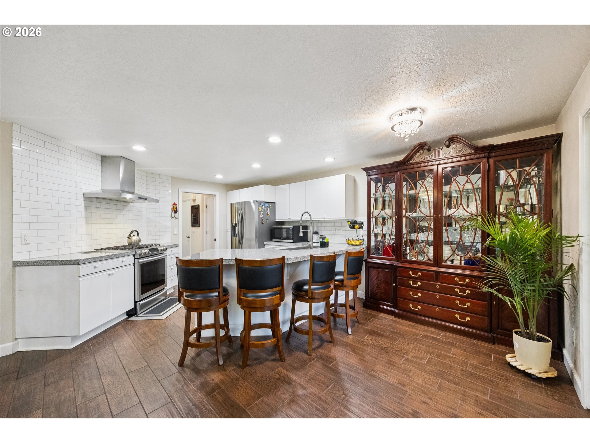 345 Southwest 207th Avenue Beaverton, OR 97006 - Photo 10 of 28 a open kitchen with stainless steel appliances granite countertop a refrigerator a sink a stove and white cabinets with wooden floor