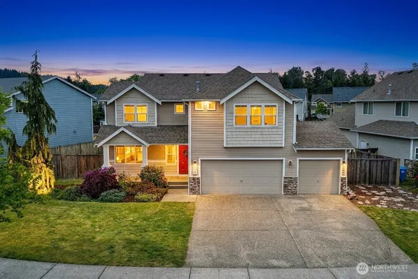 a front view of a house with a yard and garage