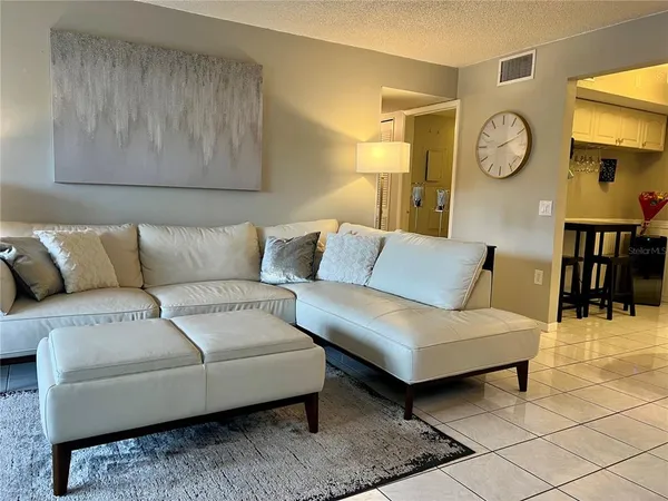 a living room with furniture and a wall painting