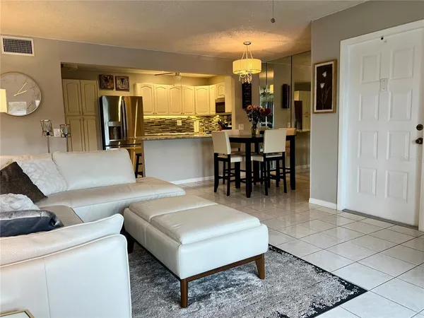 a living room with couches a dining table and chairs with wooden floor