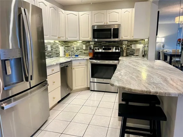 a kitchen with kitchen island granite countertop a stove sink and microwave
