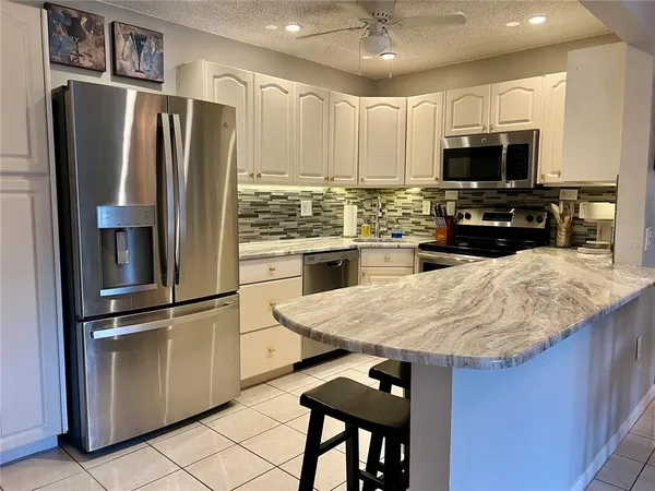 a kitchen with granite countertop a refrigerator oven a sink and dishwasher