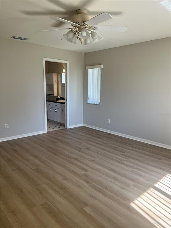 6035 Southwest 98th Street Road Ocala, FL 34476 - Photo 6 of 15 a view of empty room with wooden floor and fan