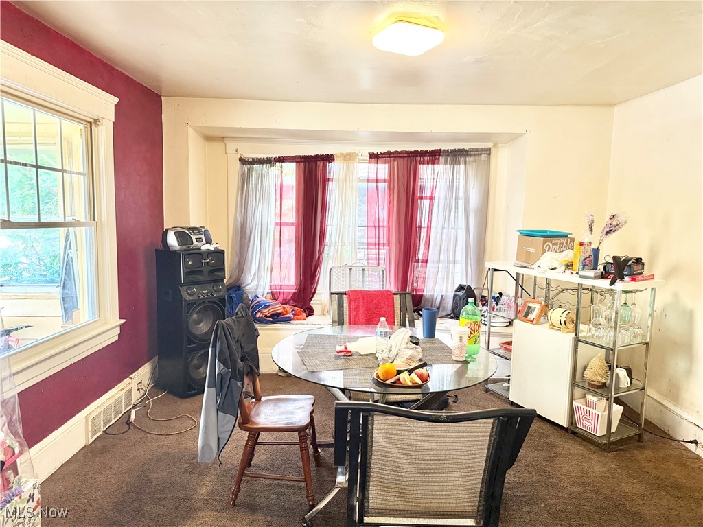 Carpeted dining room featuring baseboards