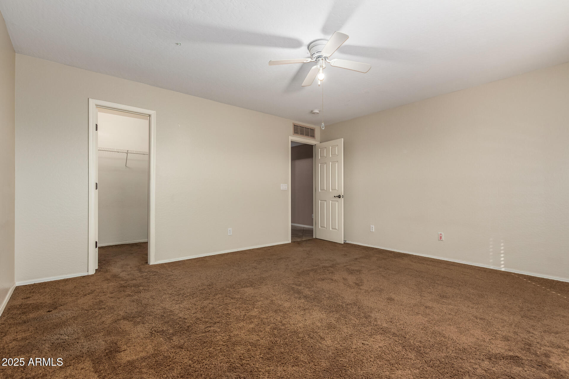 3127 West Apollo Road Phoenix, AZ 85041 - Photo 22 of 28 an empty room with a ceiling fan and carpet