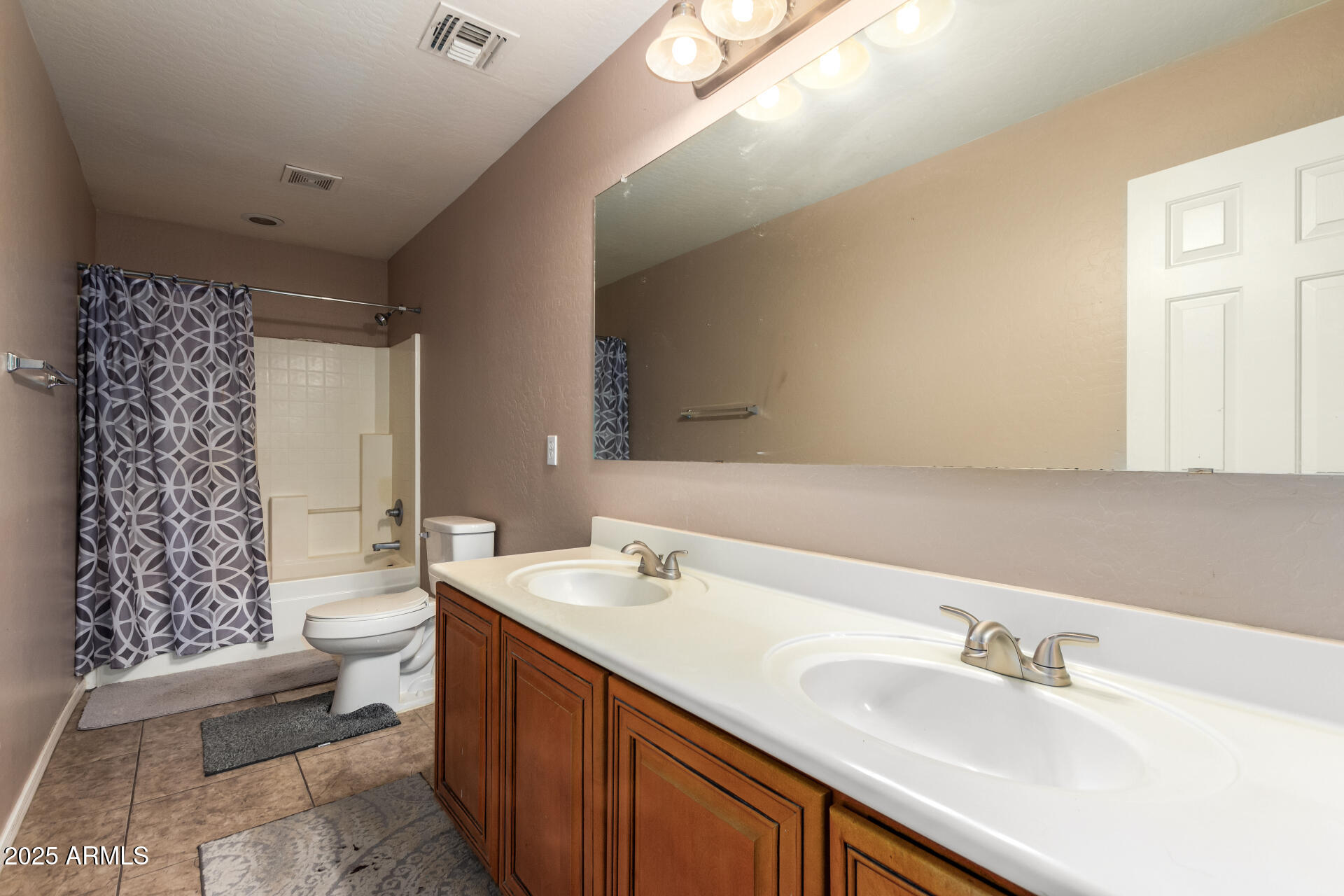 3127 West Apollo Road Phoenix, AZ 85041 - Photo 23 of 28 a bathroom with a double vanity sink toilet and shower