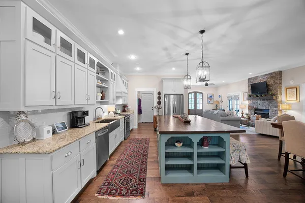 a large white kitchen with lots of counter space a sink and appliances