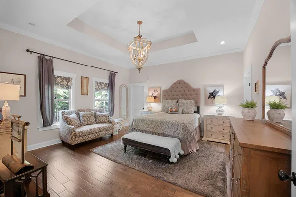 a spacious bedroom with a bed and a chandelier