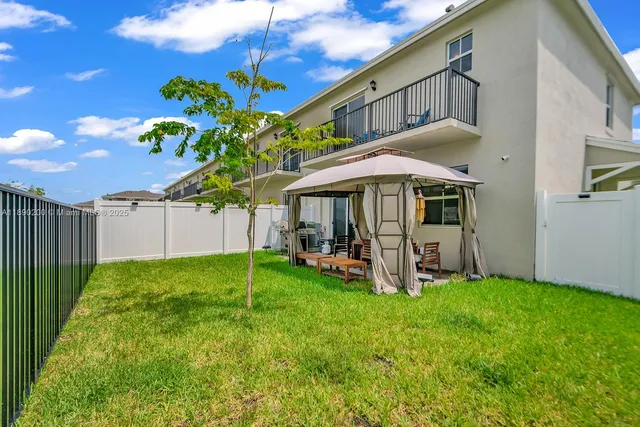 a view of a house with backyard and sitting area