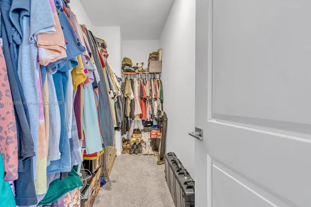 a view of walk in closet with clothes
