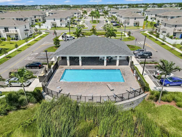 an aerial view of residential houses with outdoor space and swimming pool