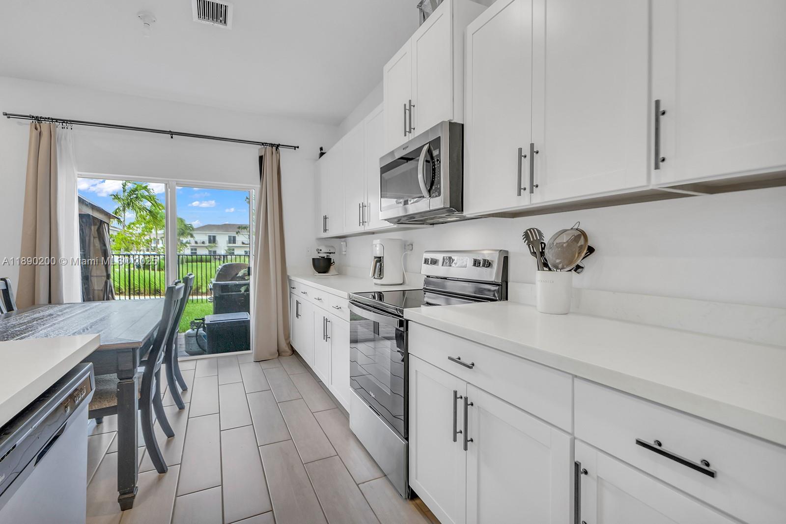 1772 Southeast 8th Street Homestead, FL 33033 - Photo 9 of 42 a kitchen with stainless steel appliances white cabinets a sink and a stove