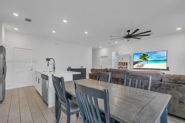 a view of a dining room with furniture and a ceiling fan