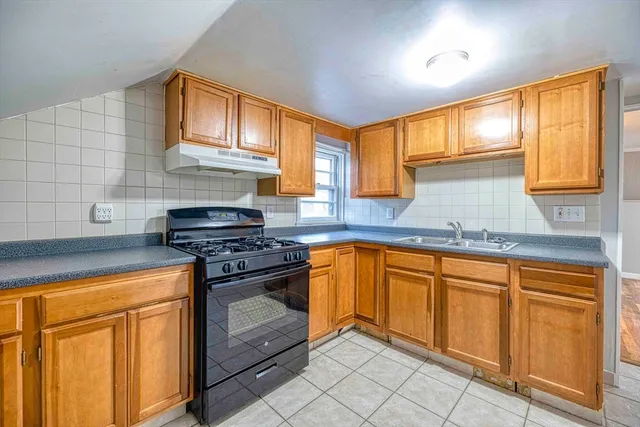 a kitchen with granite countertop cabinets stainless steel appliances a sink and a window