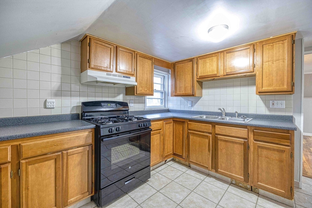 1636 South Main Street, Unit 3 Fall River, MA 02724 - Photo 4 of 14 a kitchen with granite countertop cabinets stainless steel appliances a sink and a window